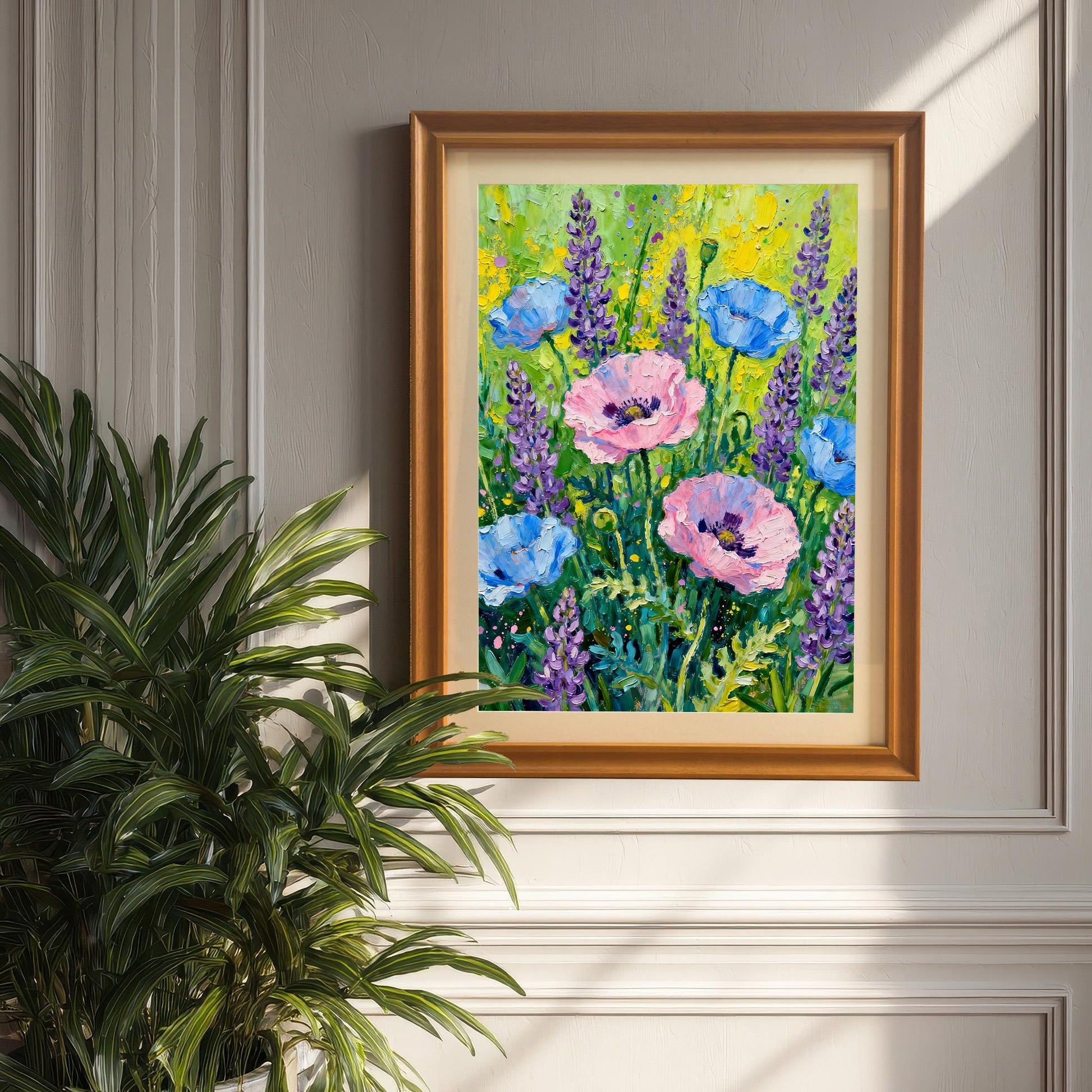 Styled photo of the poppy and lavender art print in an Orange/Brown wood frame with a mount, hanging on a light gray panel wall, next to a large potted palm plant.