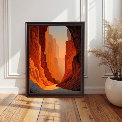 Stylized photo of the framed art print (Coffee frame, no mount) resting on a hardwood floor against a white wainscoted wall. The art features a dramatic, deep canyon with vibrant red-orange rock walls illuminated by sunset light.