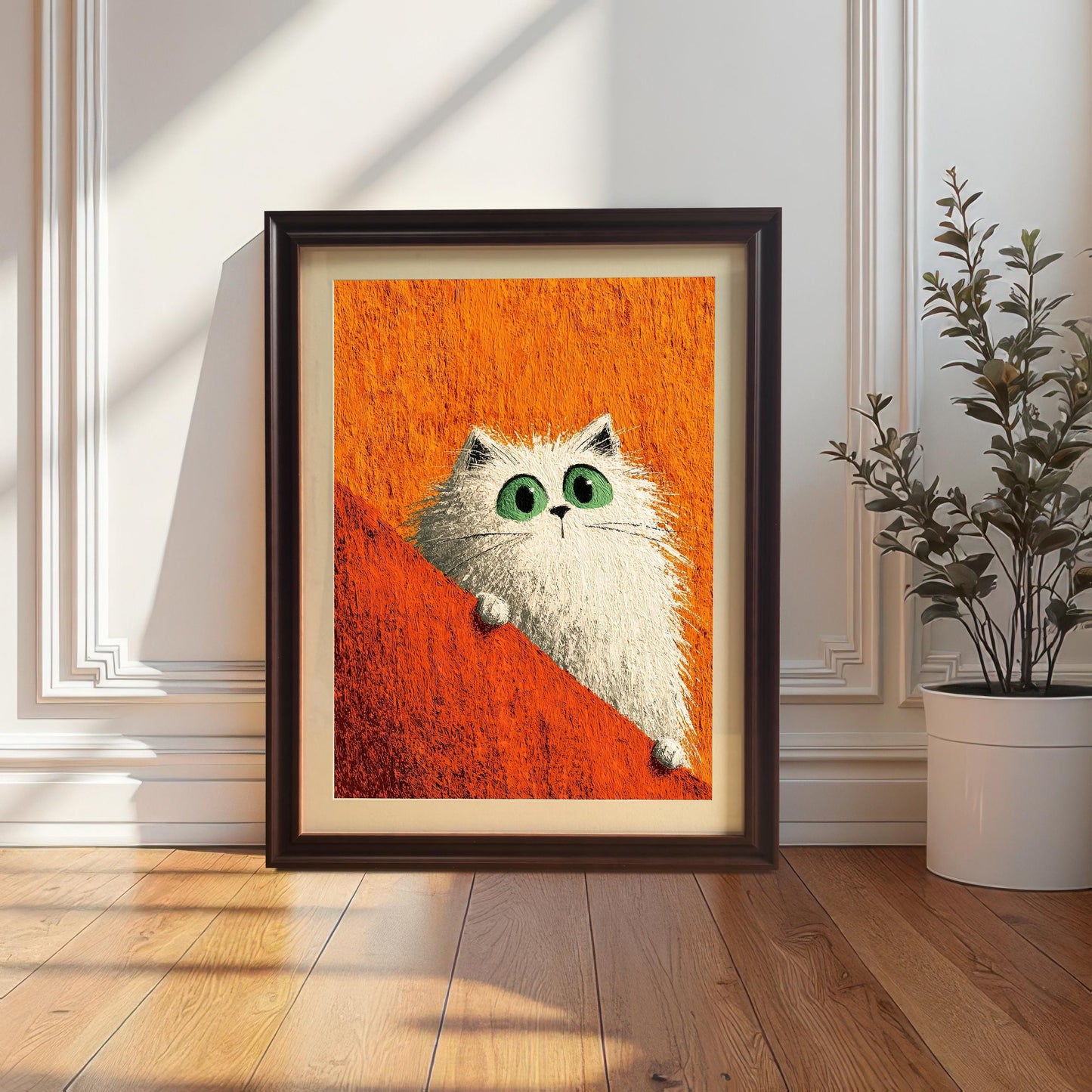 Framed print of a fluffy white cat with green eyes against an orange background, leaning against the wall on a wood floor next to a potted plant. The print is in a dark Coffee-colored wood frame.