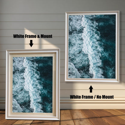 Comparison of a framed print with a White frame. The print on the left is shown with a Mount (matting), and the print on the right is shown with No Mount, both featuring a dark ocean wave photograph.