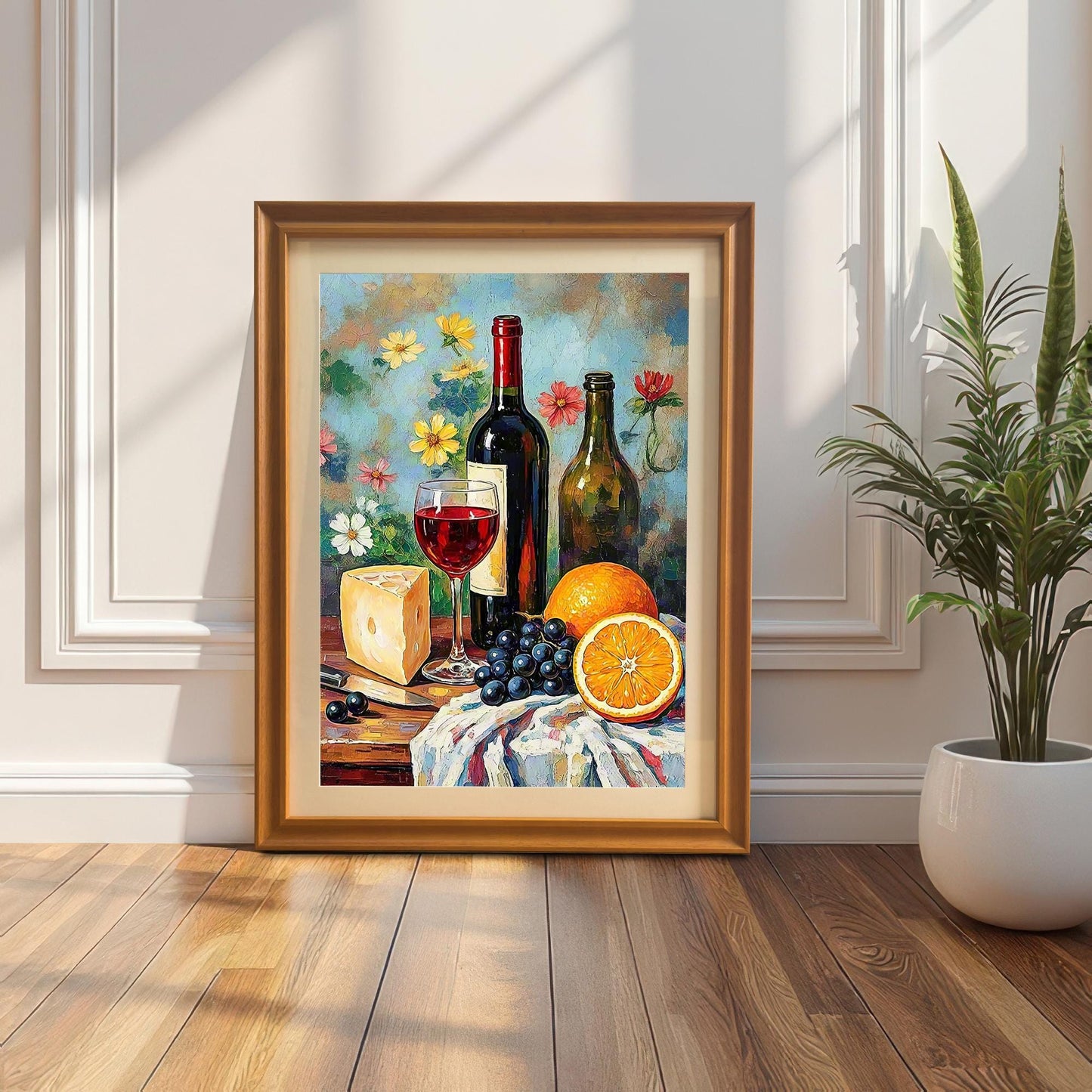The framed art print in a gold/orange wood frame leaning against a white wainscoting wall, with a snake plant in a white pot beside it.