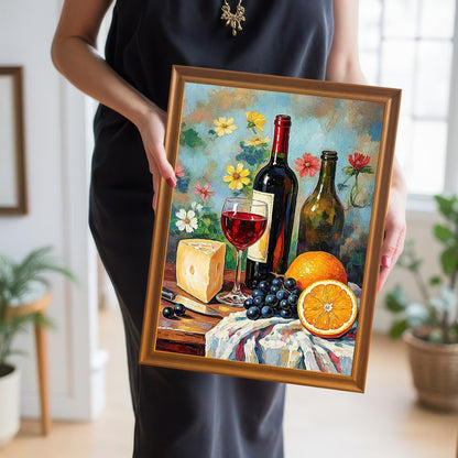 Close-up of a person holding the still life wine and fruit art print in a gold/orange wood frame. The person is wearing a black dress.