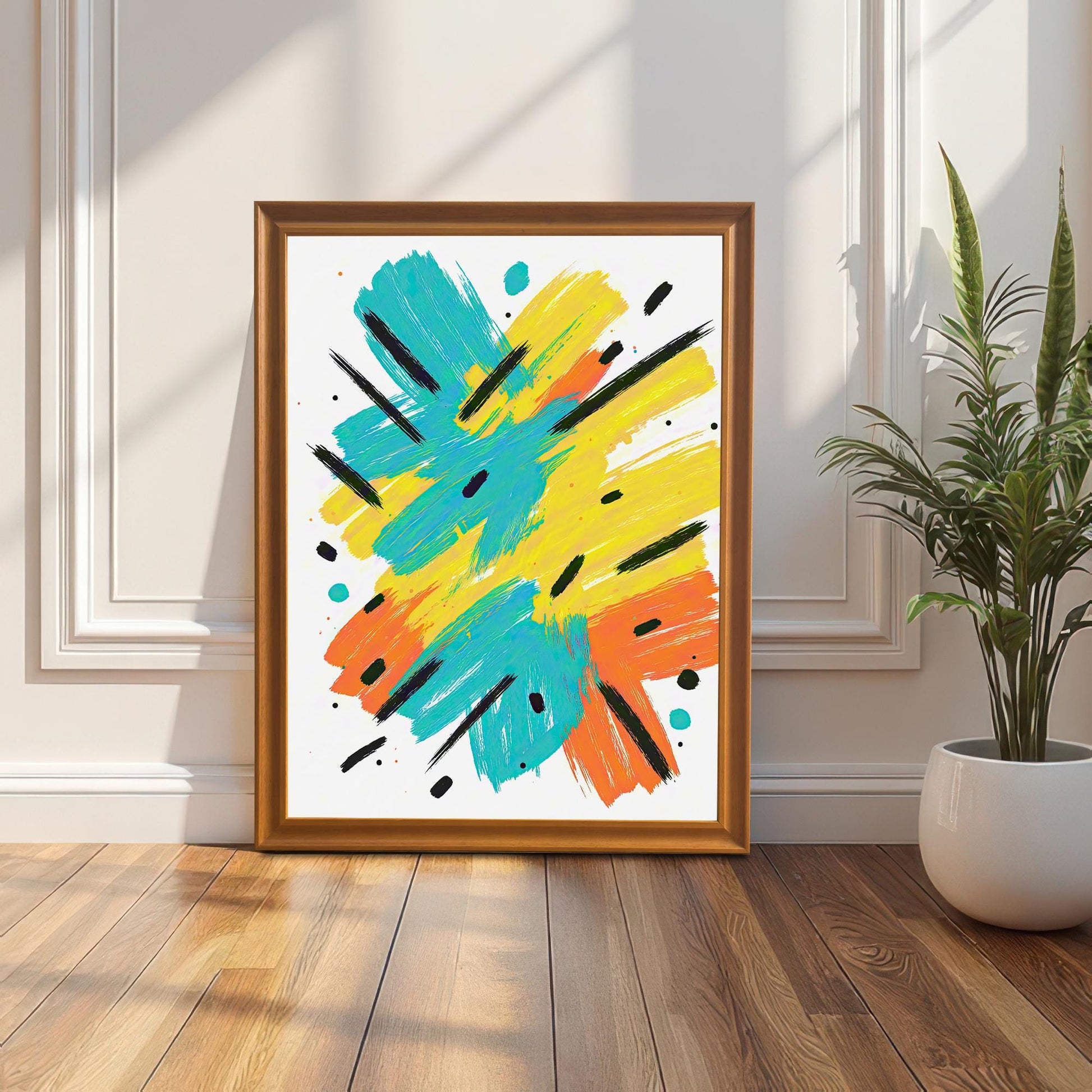 The framed abstract art print in an orange/gold wood frame leaning against a white wainscoting wall, with a snake plant in a white pot beside it.