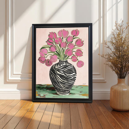 Framed print of the Pink Tulips in Zebra Vase artwork in a black wood frame without a mat/mount, leaning on a wood floor against a white wainscoted wall with natural light and shadows.