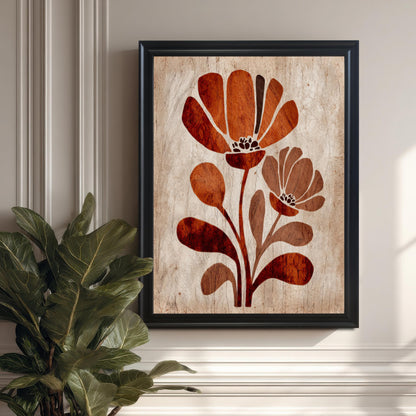 Close-up of the vertical framed art print featuring the stylized rust-orange and brown floral design. The print has a black frame and is hanging on a cream-colored wall next to the large green leaves of an indoor plant. (This focuses on the artwork detail and frame against a contrasting color.)
