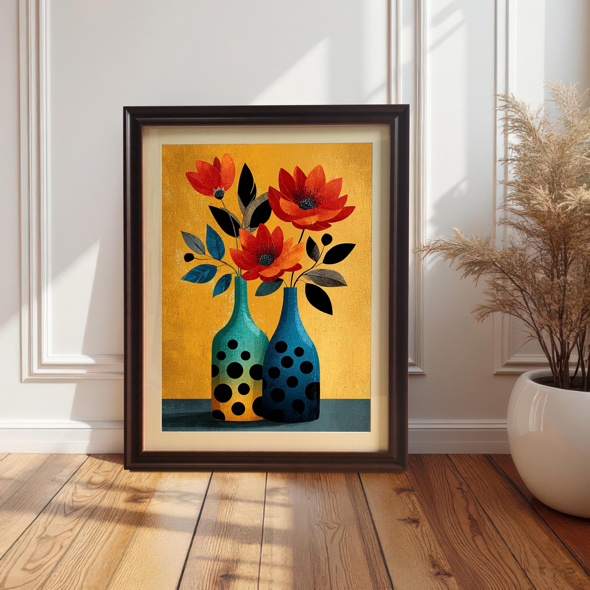 Vertical framed art print of two stylized flowers in orange and black in two polka-dot vases against a vibrant gold/mustard yellow background. The print has a Coffee/Dark Brown frame and is leaning against a white paneled wall.