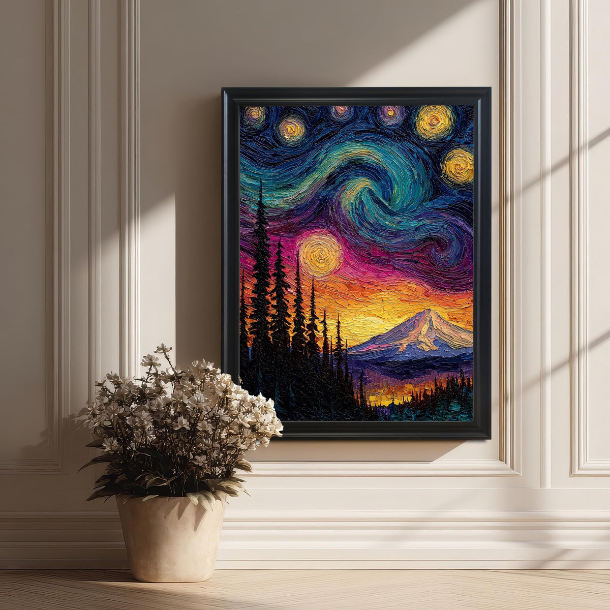 Vibrant, textured framed art print of a mountain under a swirling starry night sky, leaning against a white wainscoted wall next to a pot of dried flowers.