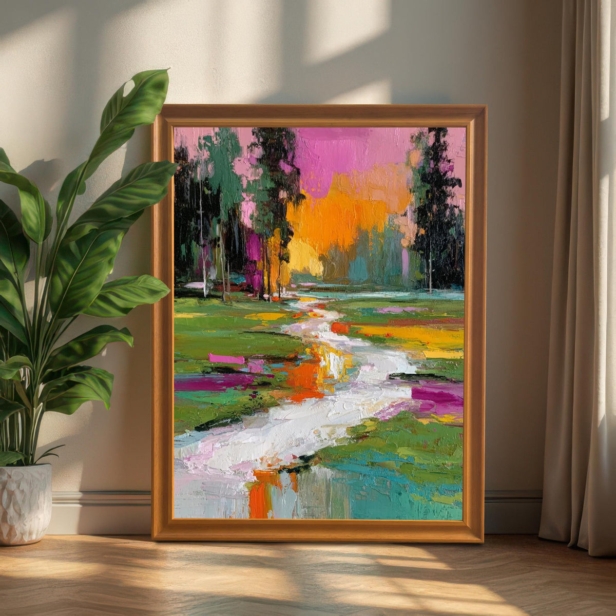 Vibrant, textured framed abstract landscape print in an orange/brown wood frame, leaning on the floor next to a large potted houseplant and curtains.