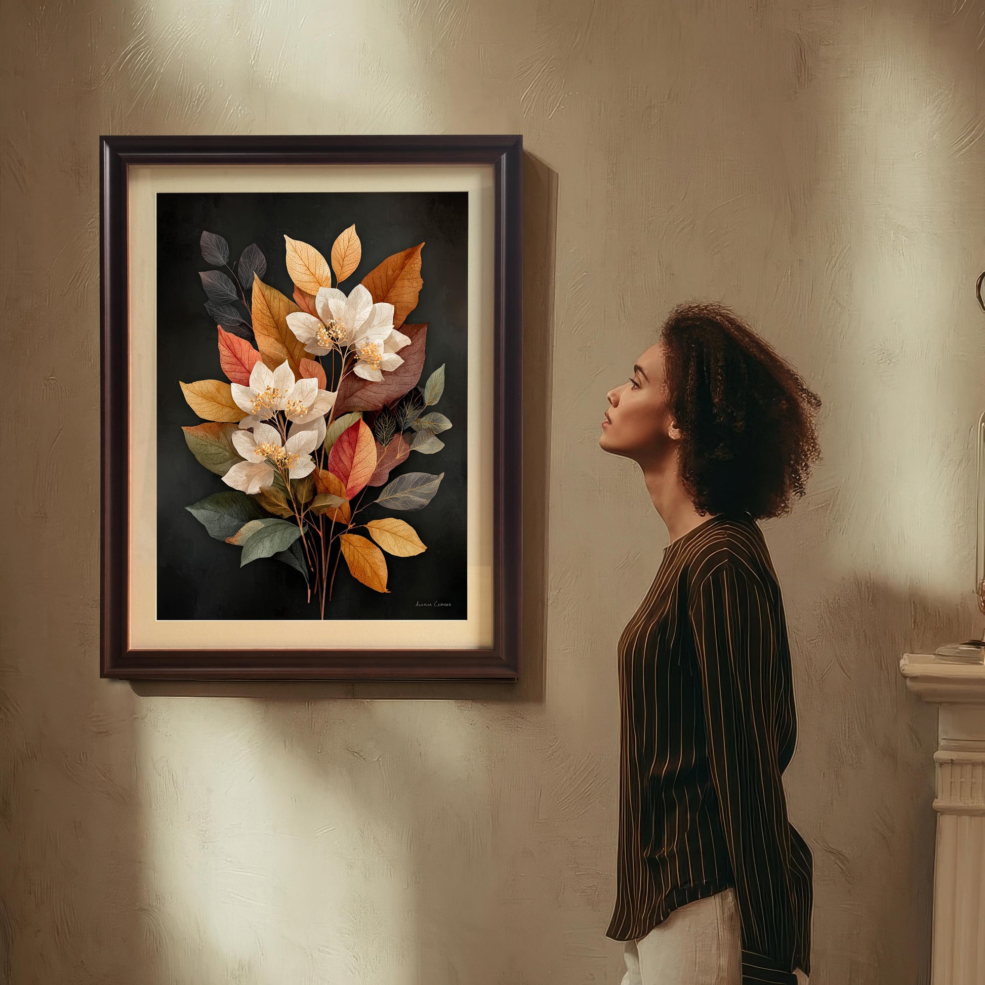 A woman with curly hair is standing and looking up admiring a framed art print of a bouquet of white flowers and autumn-toned leaves on a dark background. The art is in a dark brown (Coffee) wood frame with a mount (matting). The print hangs on a textured beige wall with dramatic shadows.