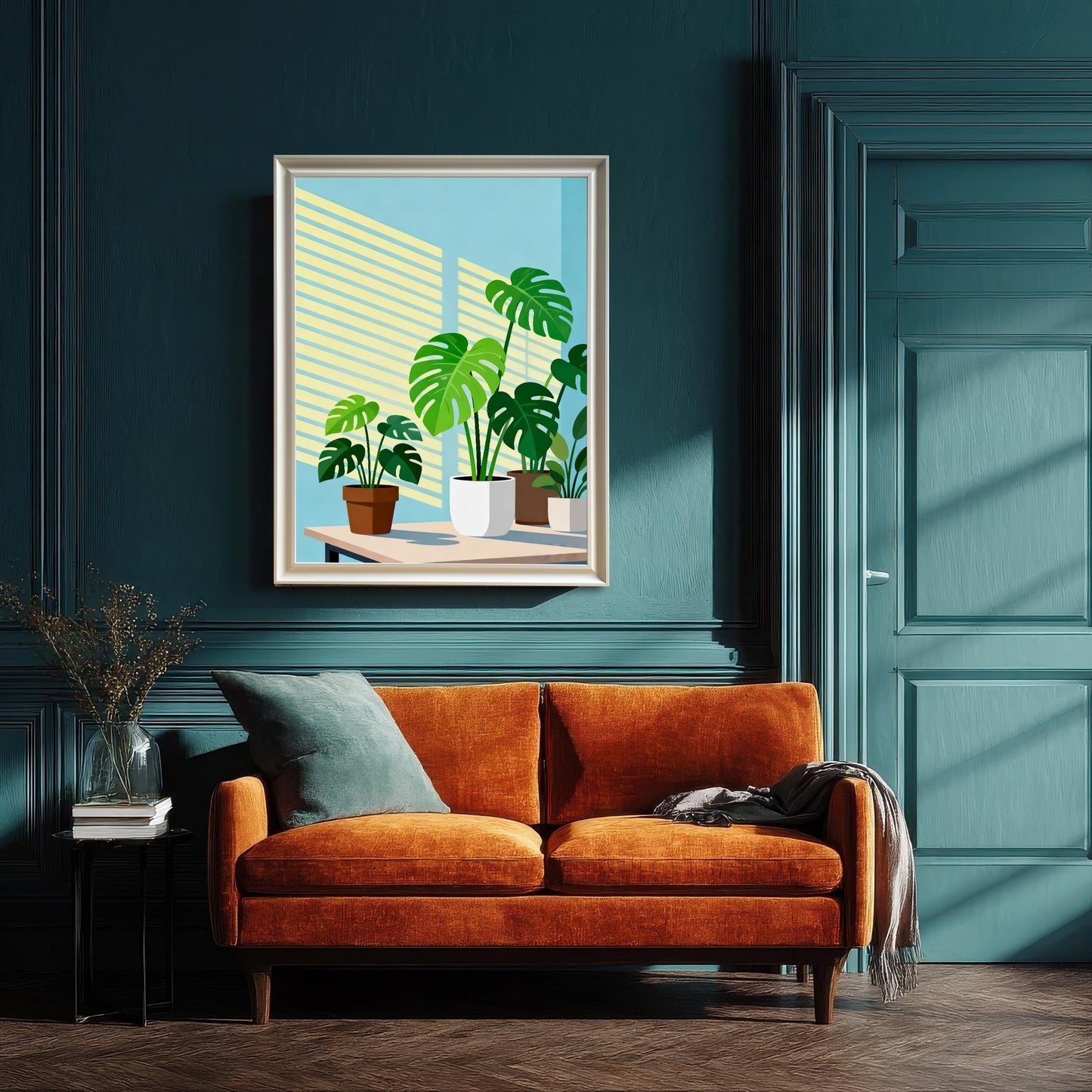 The framed 'Monstera Plants' art print hanging on a rich, dark teal/blue paneled wall. A bright orange velvet two-seater sofa with a light blue throw pillow and a small side table is placed underneath the art. The art is in a White Frame with a Mount.