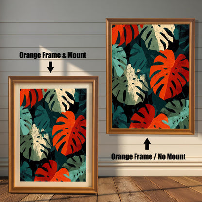 Close-up view of a framed art print featuring a repeating pattern of bold, stylized Monstera leaves in deep red, teal, cream, and dark green. The image shows two frame options: an Orange (light brown/golden) colored wood frame with a mount (matting) and an Orange wood frame with no mount around the print.