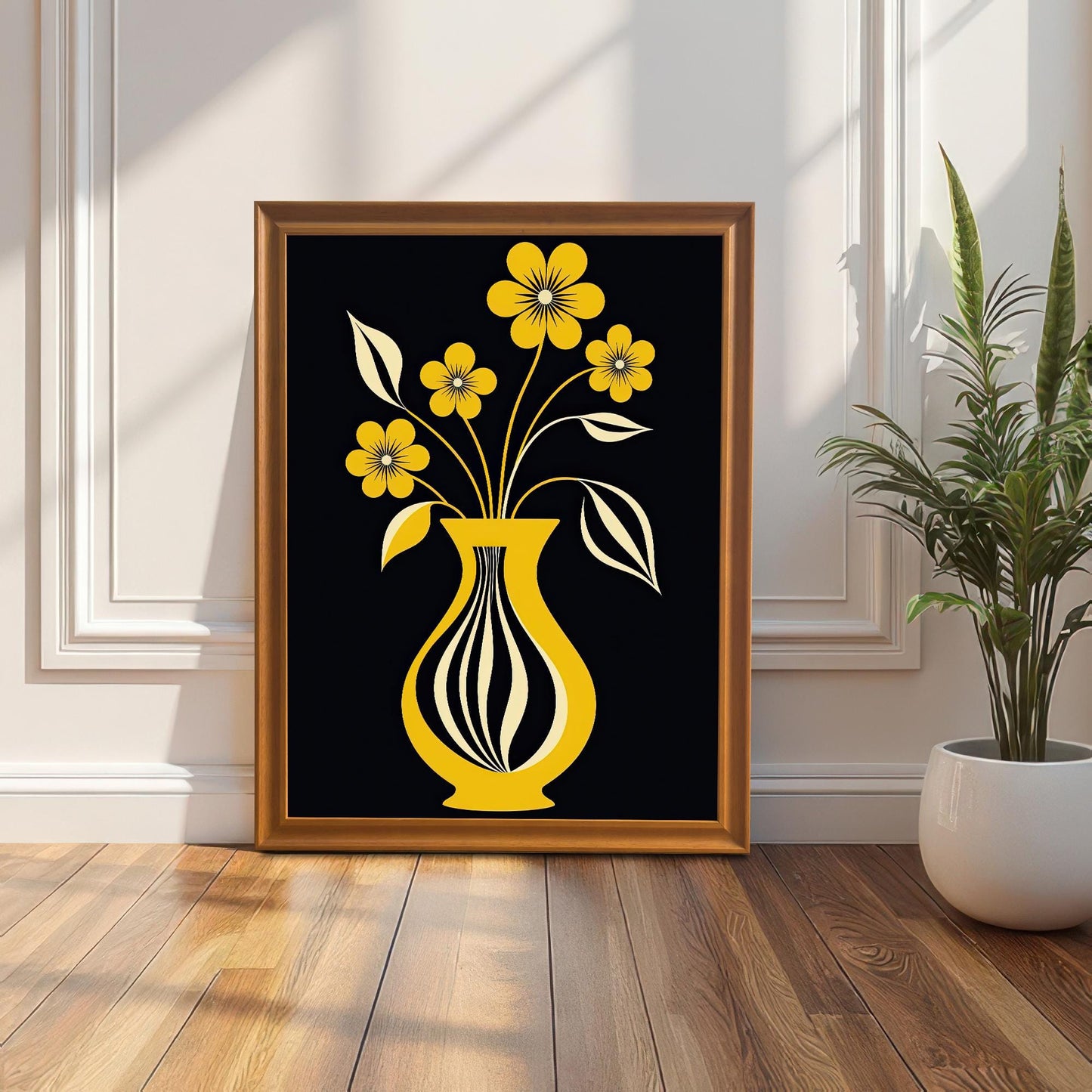 Framed yellow flower and vase art print leaning on a wood floor against a white wall with wainscoting. The frame is a gold/orange wood color. A snake plant in a white pot is on the right.