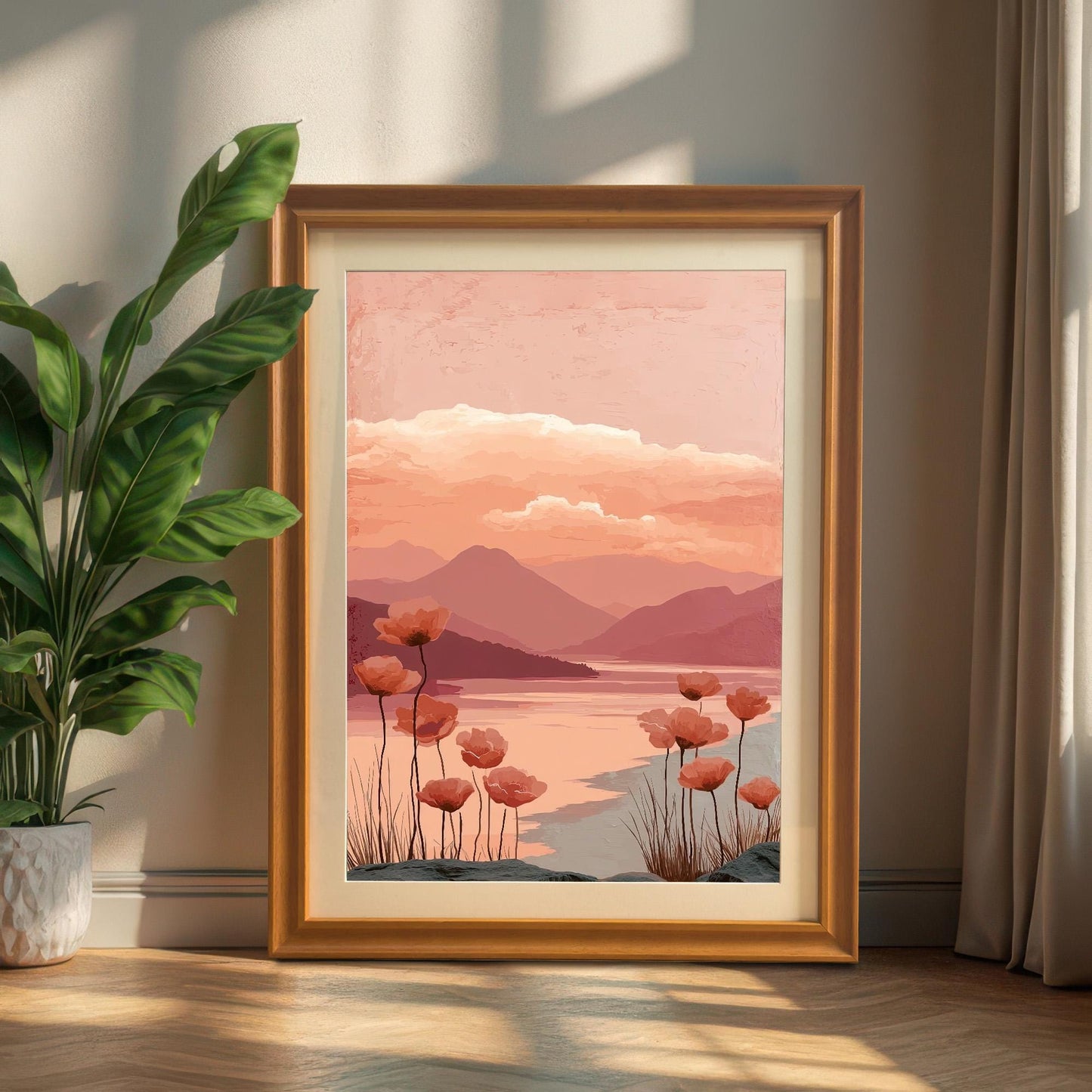 A framed art print of the poppy landscape with a light brown/wood-tone frame, leaning on a light wood floor next to a potted plant and neutral-colored curtains, bathed in sunlight.