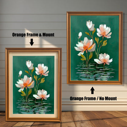 Abstract watercolor-style painting of white and pale orange water lilies on a dark green background with horizontal water reflections. The image shows two framed options: one on the left with an Orange Frame & Mount (matting), and one on the right with an Orange Frame / No Mount. Both are displayed against a white wood-paneled wall and a wooden floor.