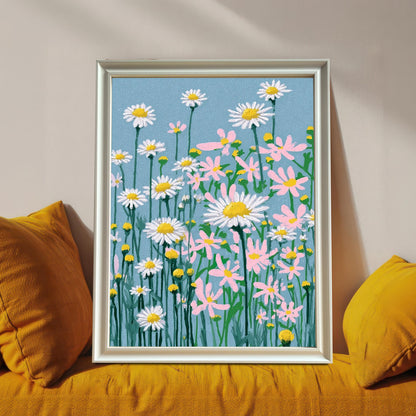 A framed art print of the daisy field illustration, set in a White frame (no visible mount), leaning on a sofa between two bright yellow pillows.