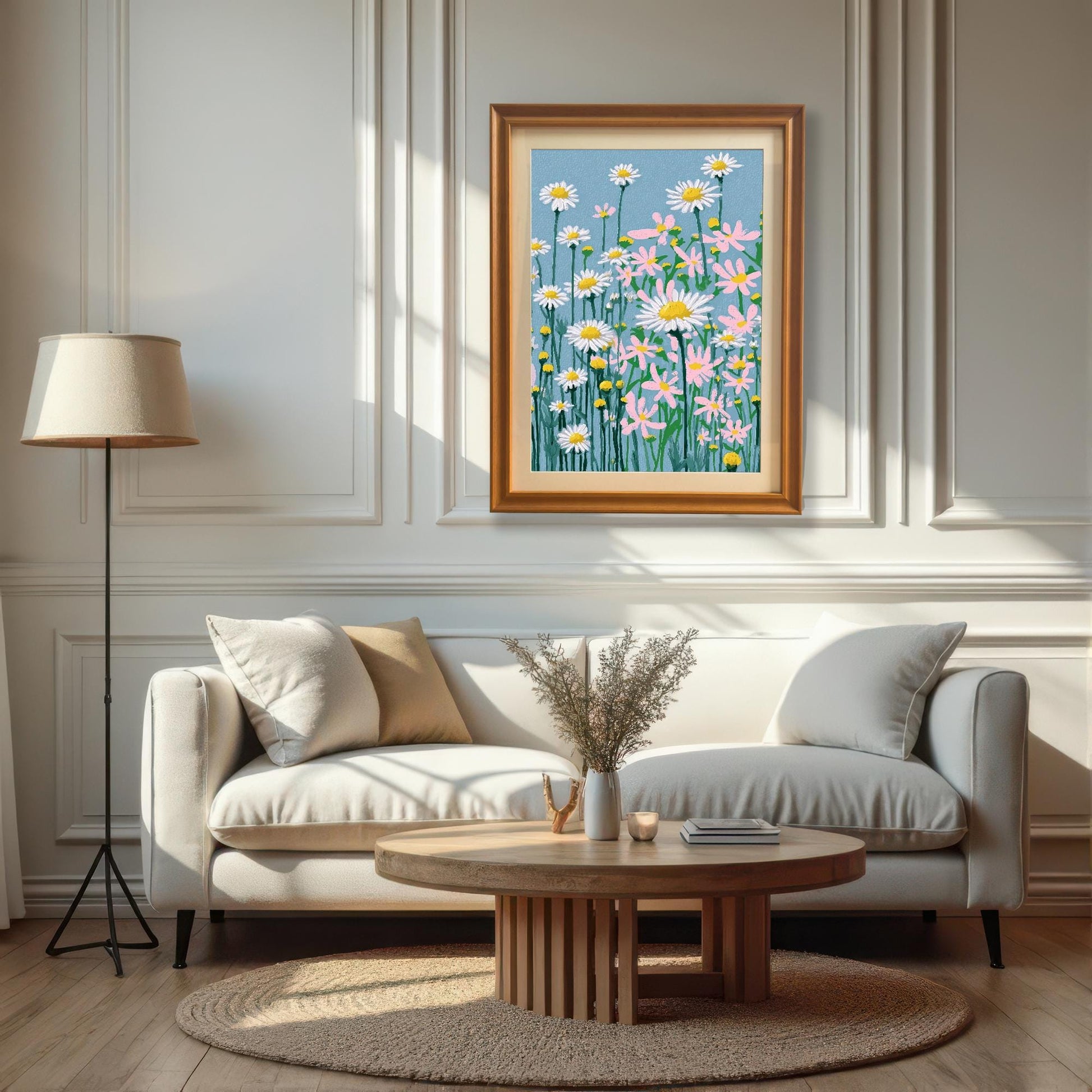 A framed print of the daisy field illustration, set in an Orange/Wood frame with a mat, hanging above a white sofa and a round wooden coffee table in a bright, sunlit living room.