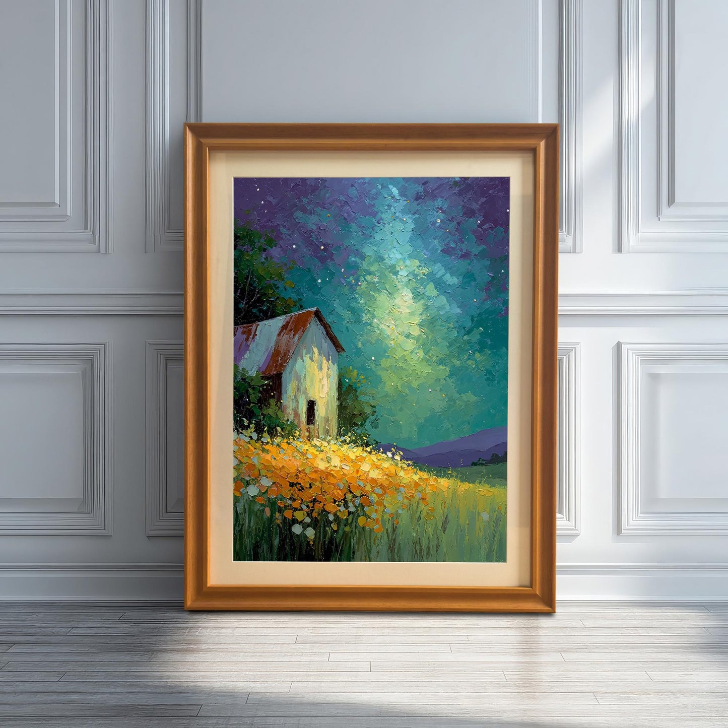Artwork of a barn under a starry sky, framed in Orange wood with a mat, leaning on a wooden floor against a white paneled wall with strong sunlight and shadows.