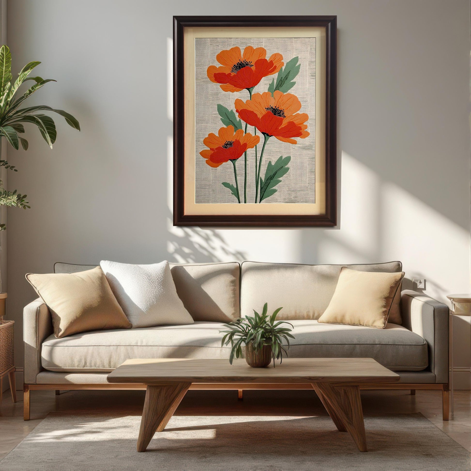 Lifestyle photo showing the framed artwork of three stylized orange poppies on a textured cream background, hanging on a white wall above a beige sofa and a wooden coffee table. The frame is dark brown/Coffee and includes a visible light-colored mount (mat).
