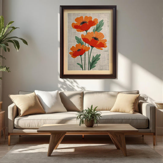 Lifestyle photo showing the framed artwork of three stylized orange poppies on a textured cream background, hanging on a white wall above a beige sofa and a wooden coffee table. The frame is dark brown/Coffee and includes a visible light-colored mount (mat).