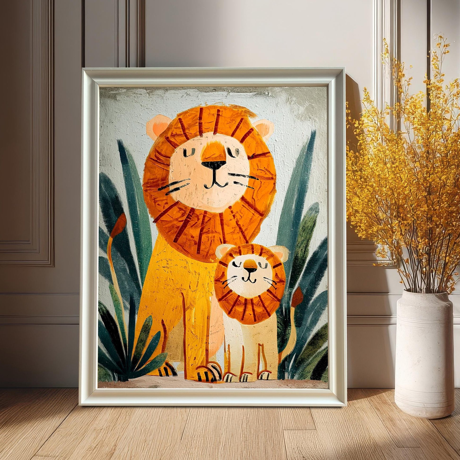A framed print featuring a cartoonish oil painting of a father lion and a cub sitting in jungle foliage. The print is in a white or silver-colored frame, leaning on a hardwood floor against a white wainscoted wall. A tall, cream-colored vase with dried yellow flowers sits next to it.