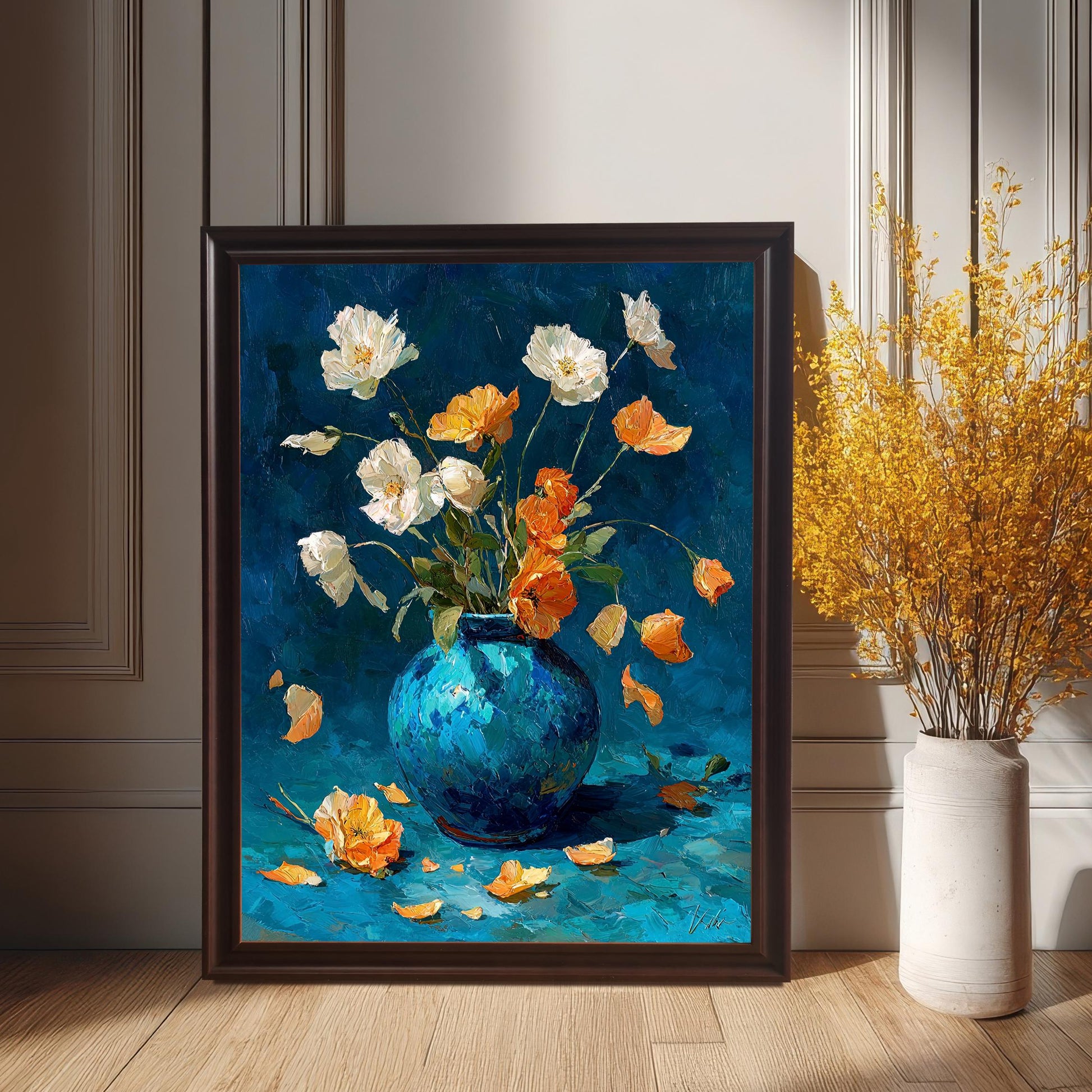 The framed floral oil painting in a dark brown (Coffee) frame, leaning on a wooden floor against a white wainscoted wall, positioned next to a tall white vase holding a large bouquet of yellow dried flowers.