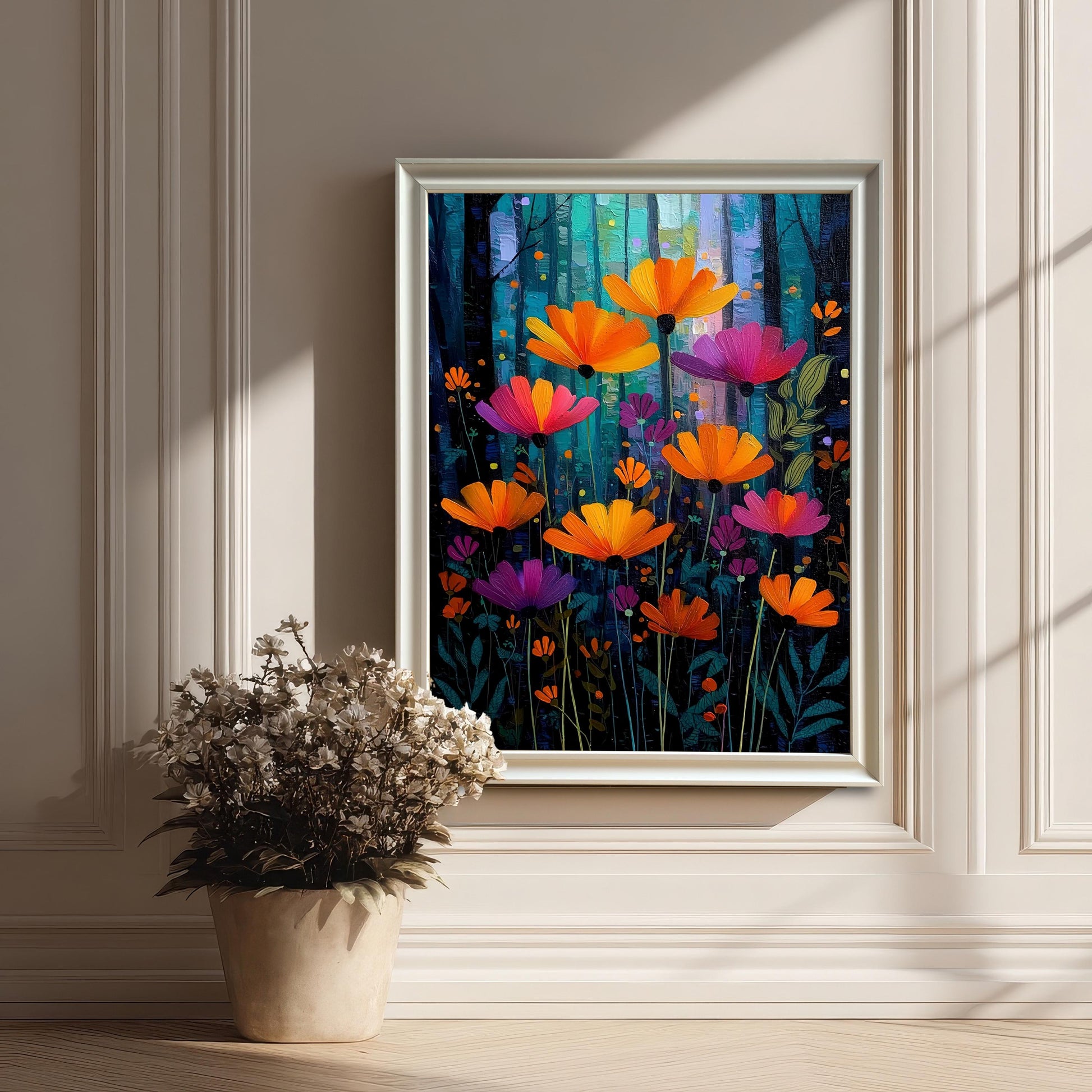 The vibrant painting of orange and magenta flowers, framed in a decorative white frame (no mount), leaning on a light hardwood floor against a white paneled wall. A dried floral arrangement in a pot is in the foreground.