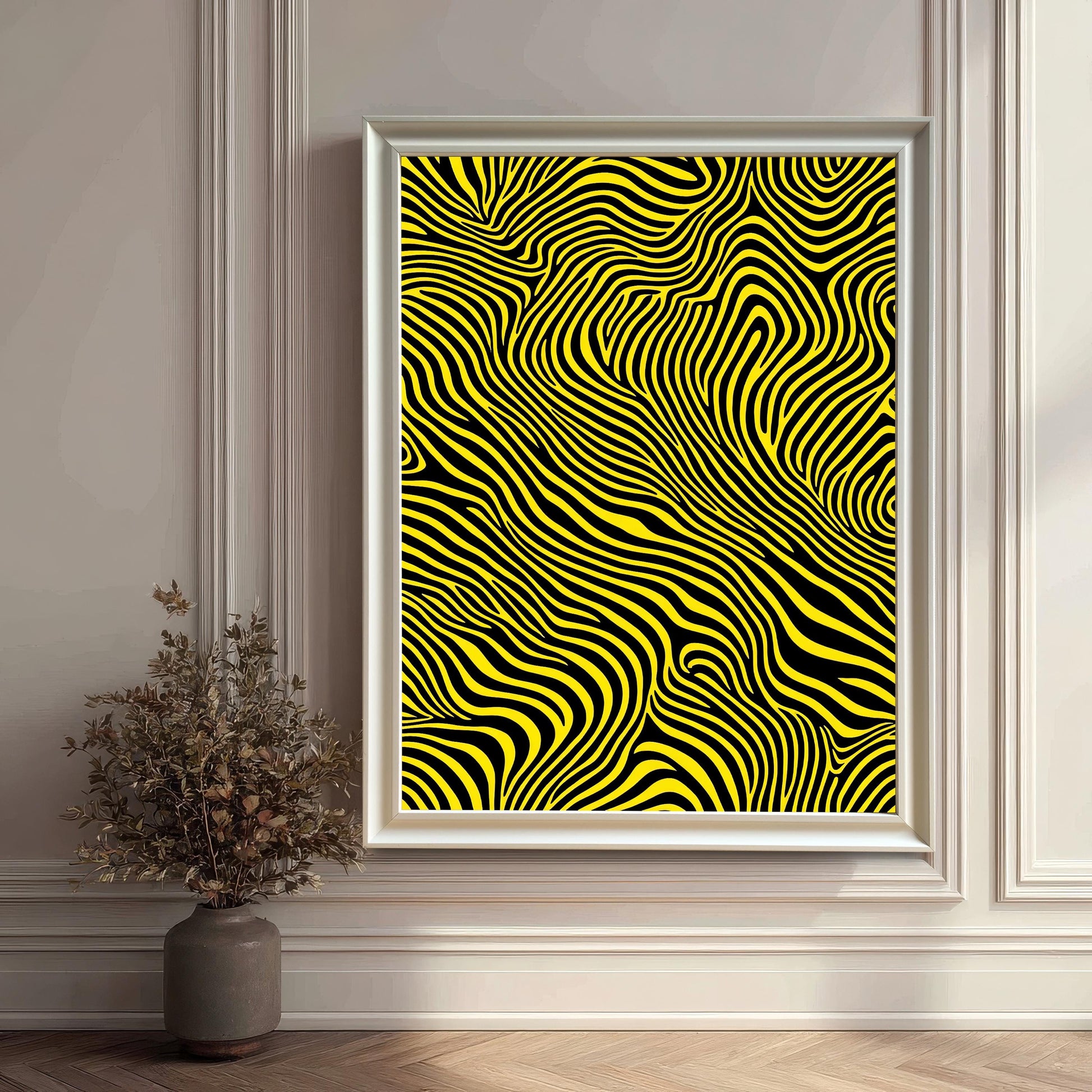 The abstract yellow and black striped print framed in a decorative white frame (no mount), leaning on a light hardwood floor against a decorative white paneled wall. A dried floral arrangement in a vase is placed to the left.