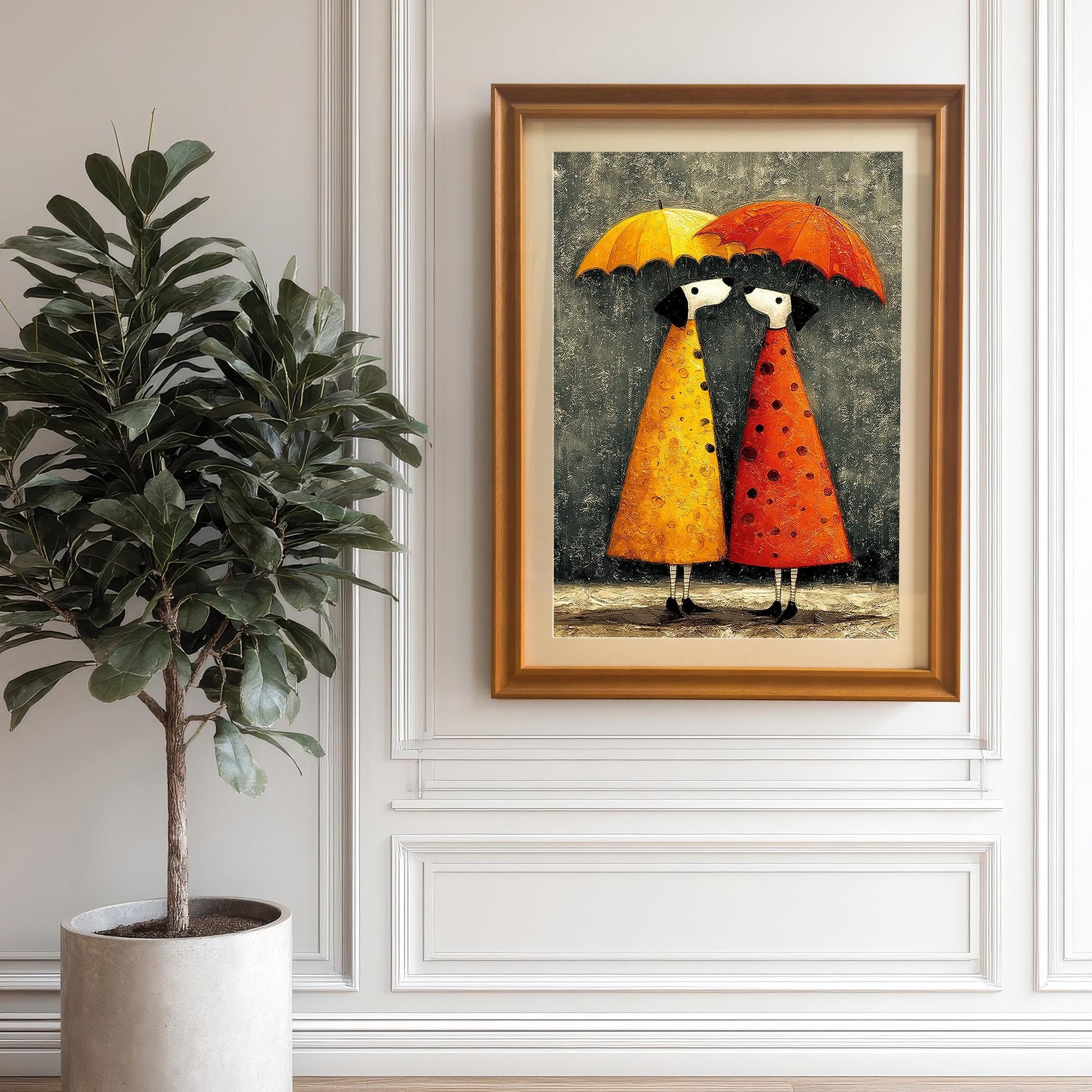 The umbrella couple art print framed in Orange/Gold/Wood Tone and hanging on a white wall with wainscoting paneling. A large potted ficus tree is positioned to the left.