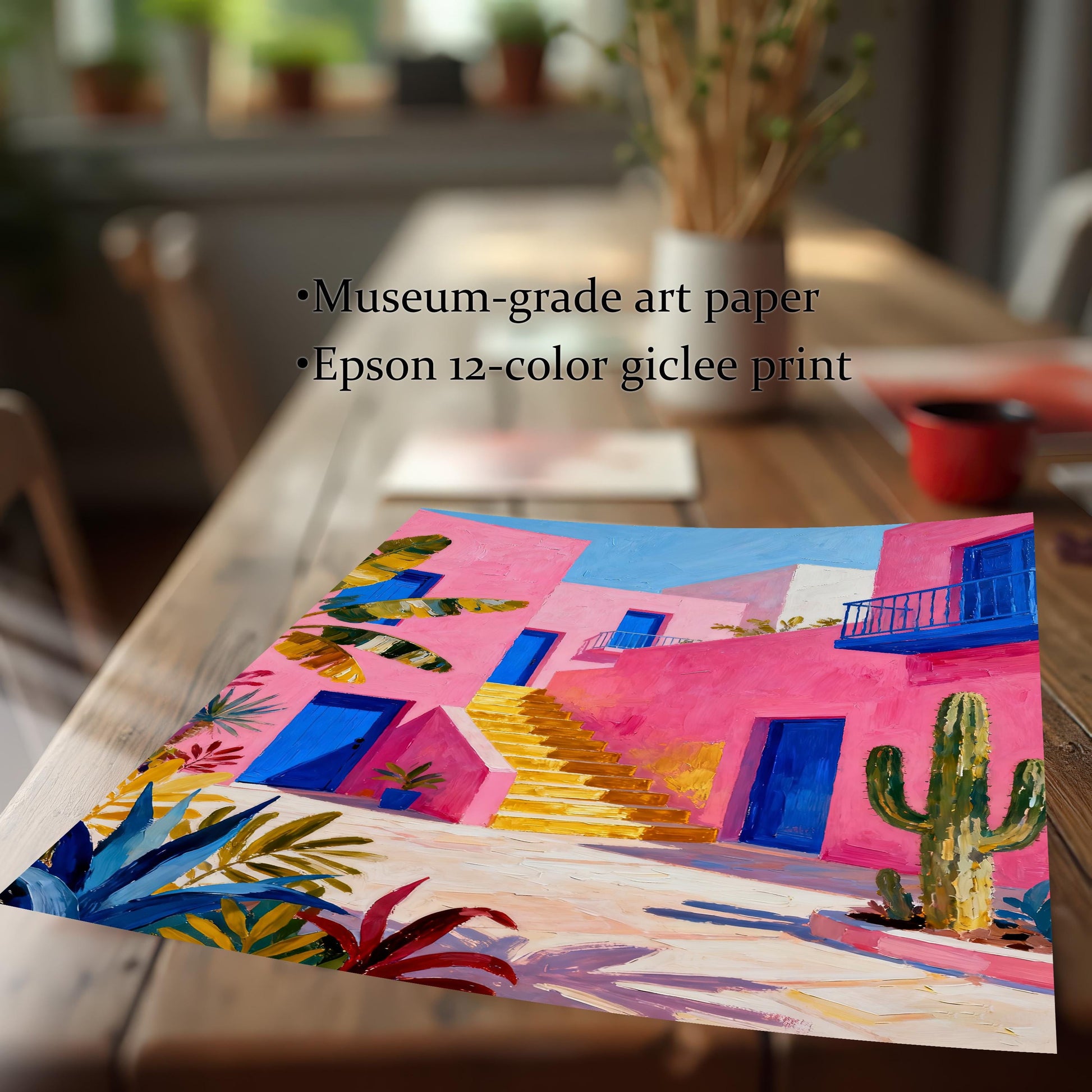 A high-quality print of the vibrant pink building art lying on a wooden table, with text describing the materials: "Museum-grade art paper" and "Epson 12-color giclee print".