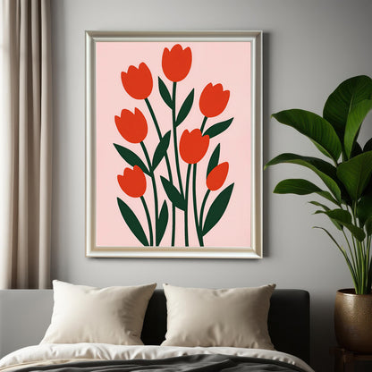 A framed, modern illustration of red tulips with dark green leaves on a light pink background hanging above a bed with cream pillows and next to a large potted plant.