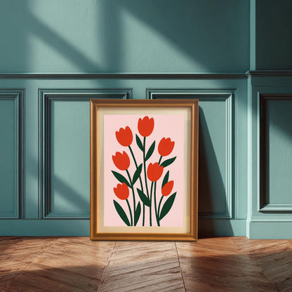 A gold-framed print of red tulips on a pink background is leaning on a wooden floor against a textured teal paneled wall. Sunlight casts strong, angular shadows.
