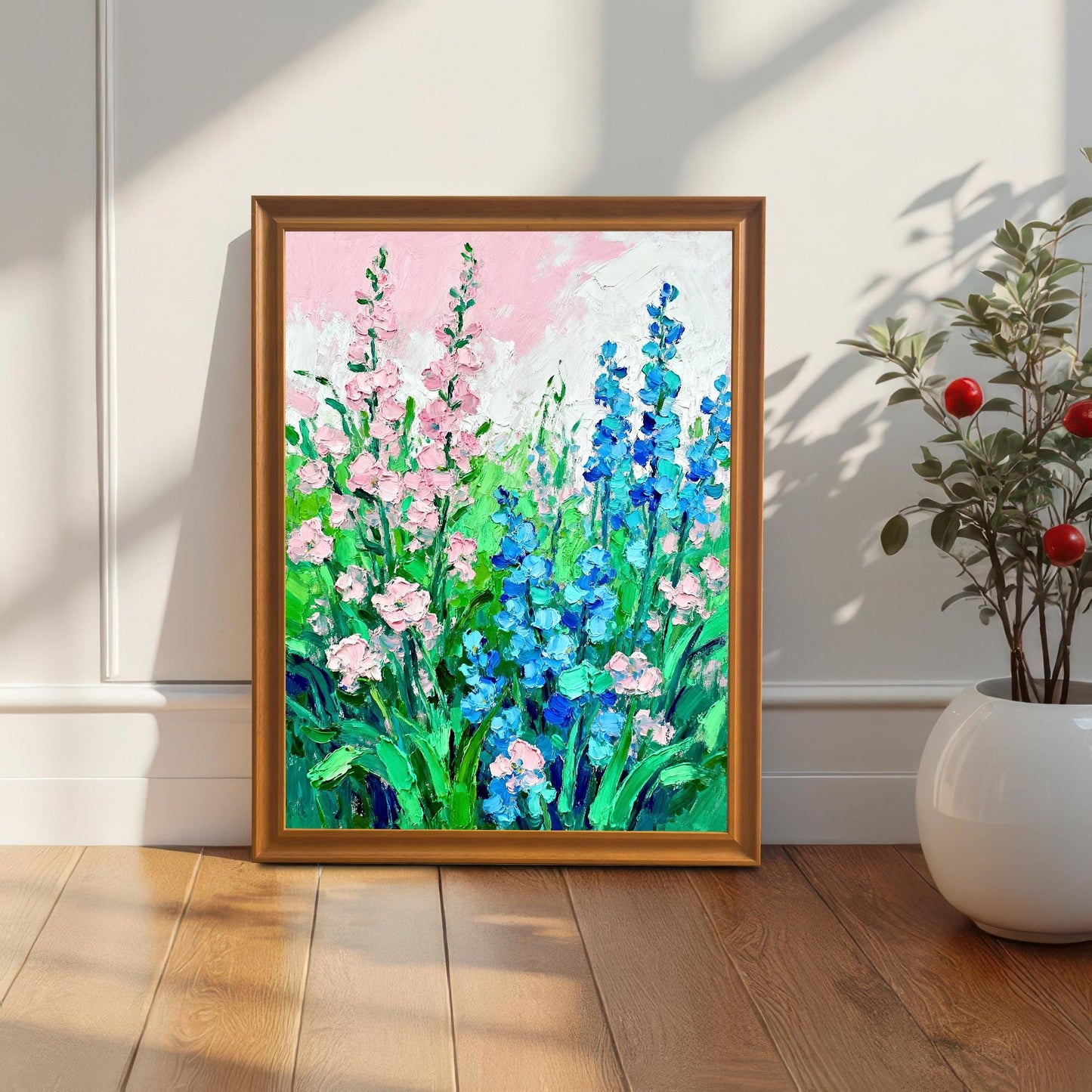 Styled photo of the floral art print in an Orange/Brown wood frame, leaning against a white wall next to a houseplant, illuminated by natural light.
