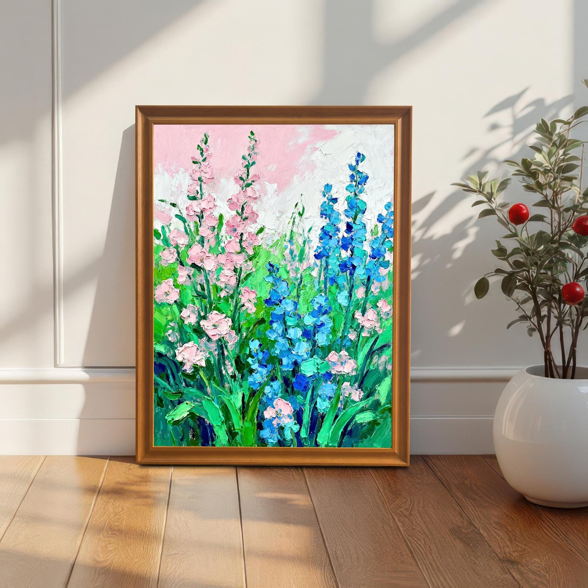Styled photo of the floral art print in an Orange/Brown wood frame, leaning against a white wall next to a houseplant, illuminated by natural light.
