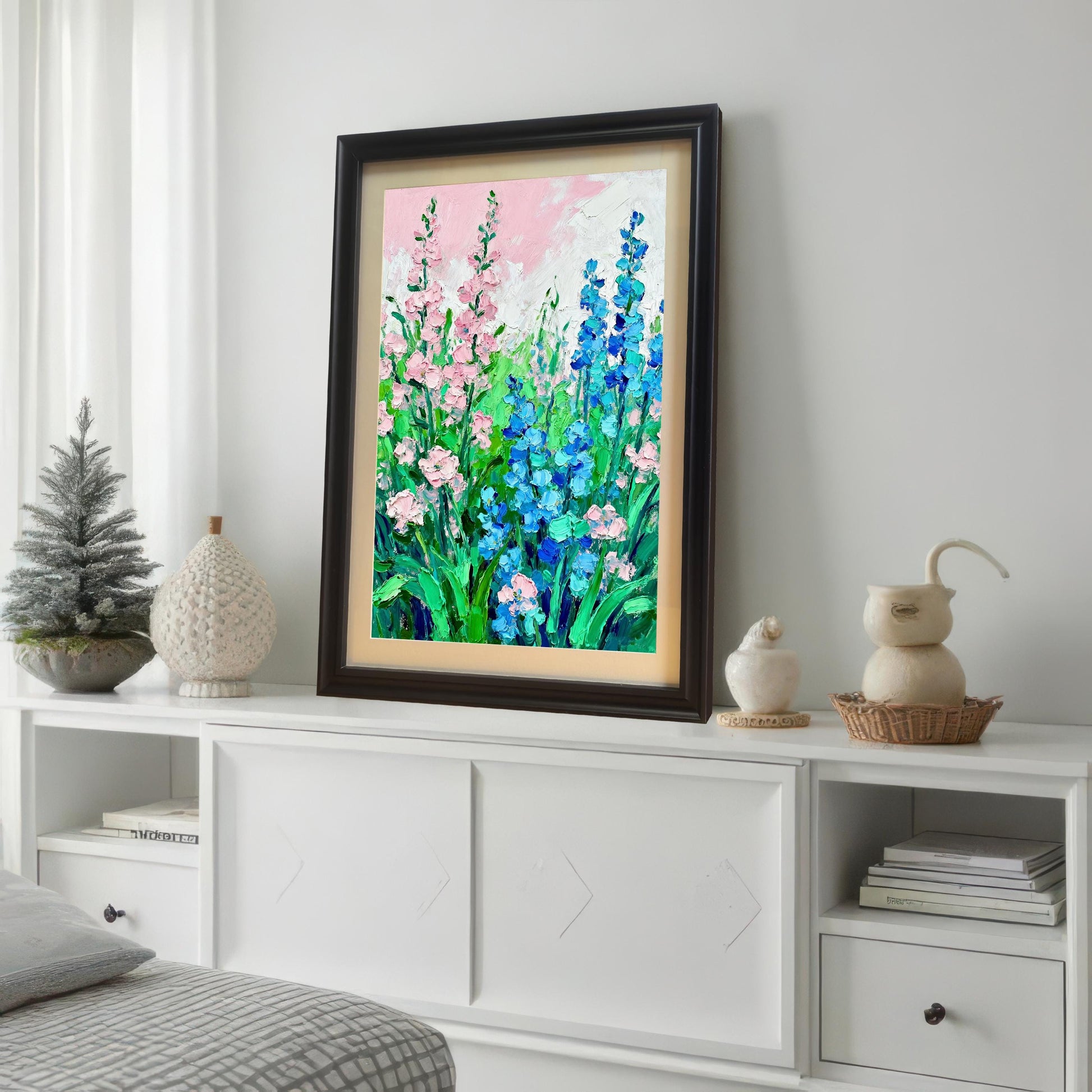 Styled photo of the floral art print in a Dark/Coffee frame with a mount, displayed on a white console table in a bedroom setting next to small decorative objects and a small Christmas tree.