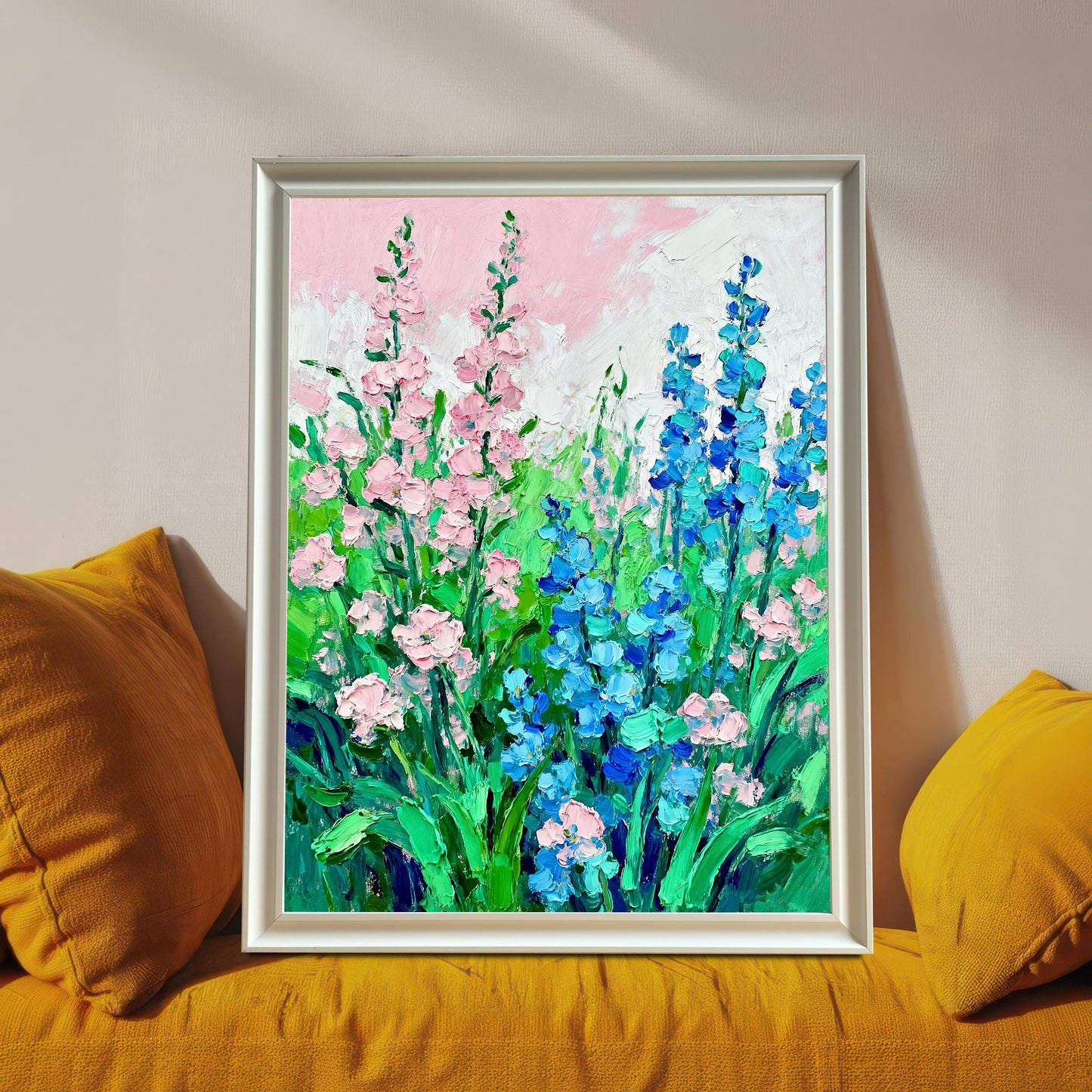 Styled photo of the floral art print in a White frame, resting on a bright yellow couch or cushions.
