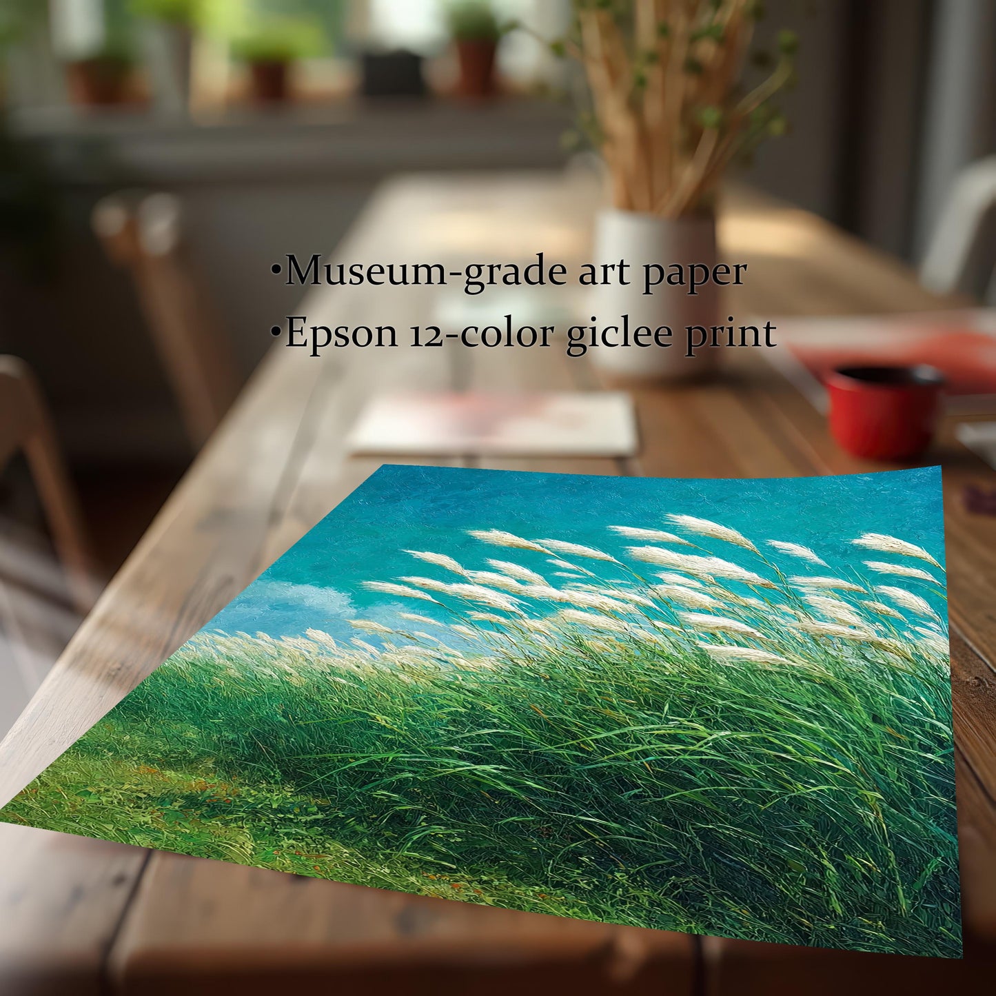 Detail shot of the art print of the windy grass field, laying on a wooden table. Text overlay highlights product quality: Museum-grade art paper and Epson 12-color giclee print.