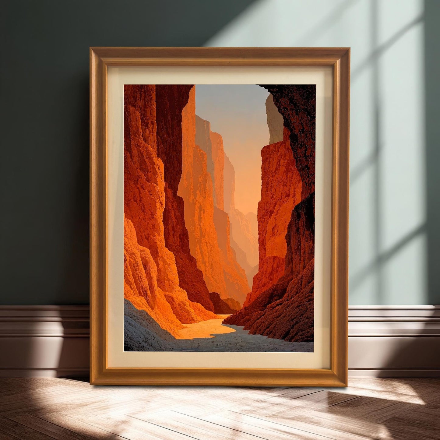 Stylized photo of the framed canyon art print (Orange frame with mount) resting on a wooden floor against a dark wall, illuminated by a strong sunlight shadow.