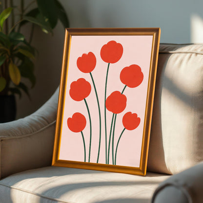Framed print of red poppy-like flowers in an Orange-colored wood frame leaning on a plush, light-colored armchair bathed in sunlight.