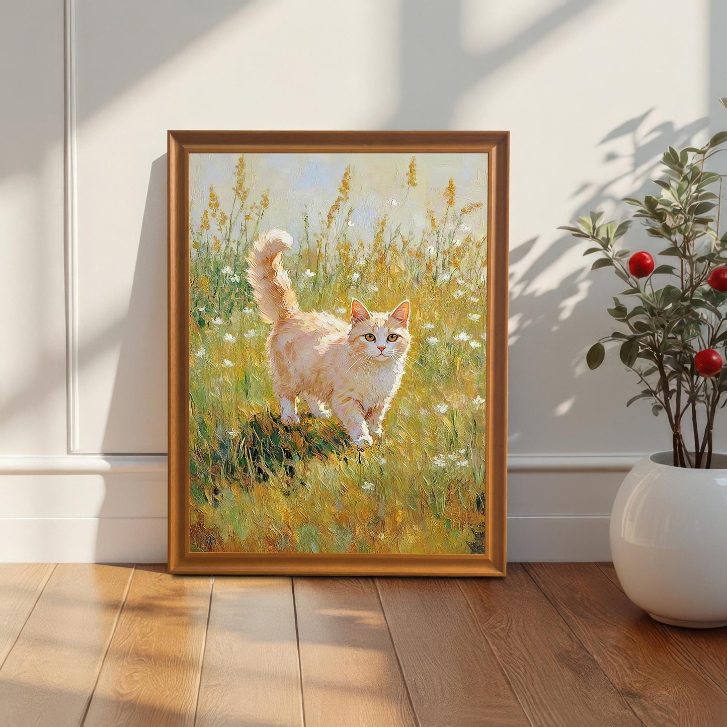 The cat art print in an Orange frame leaning against a white wall and baseboard, next to a white vase with decorative red berries. Sunlight streams from the upper right.