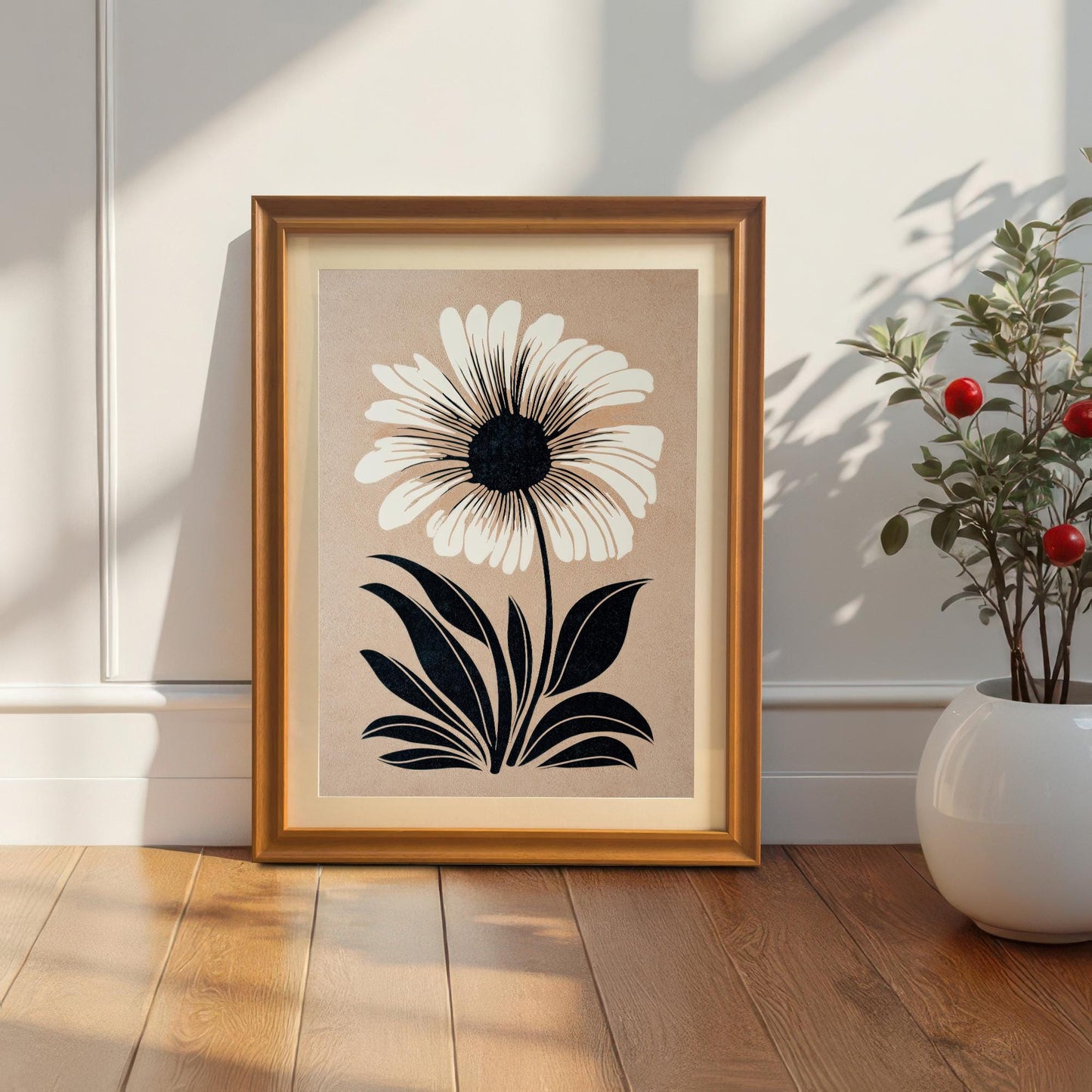 Lifestyle photo of the art print in an Orange wood frame with a mat/mount, leaning on the floor against a white wall next to a small potted plant.