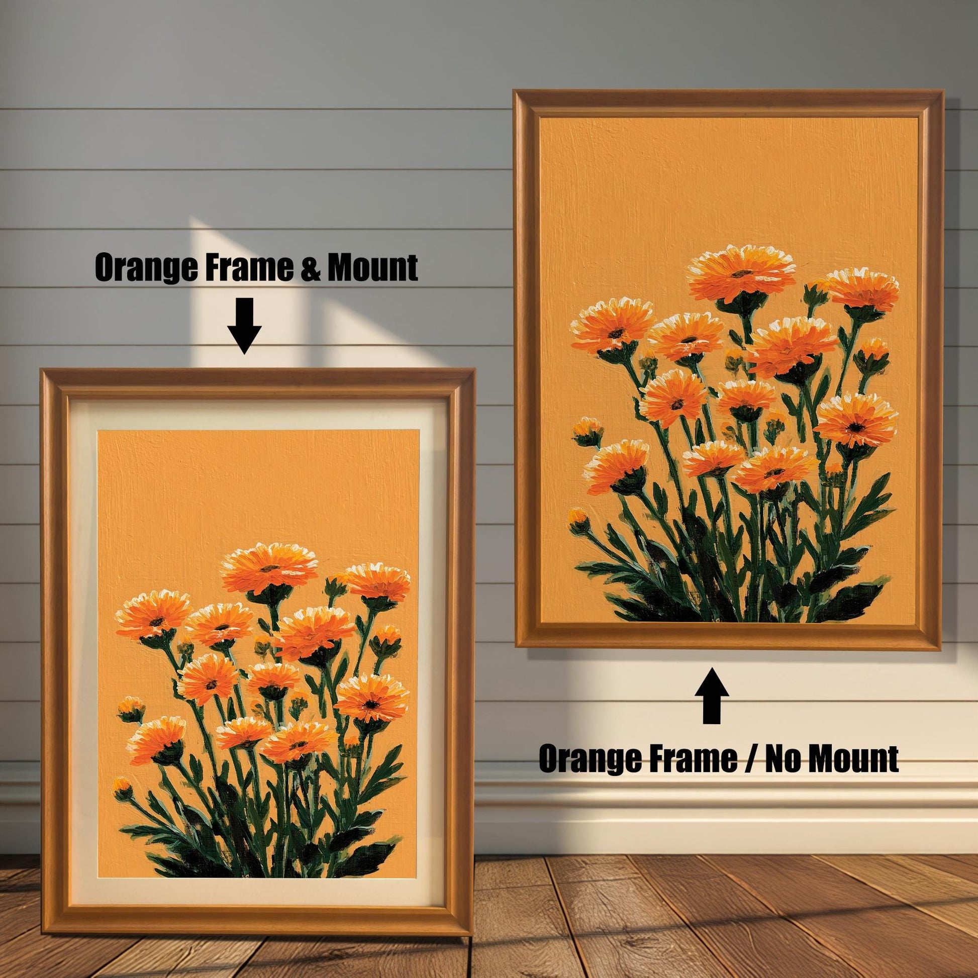 Two framed orange floral art prints against a white wood panel wall and wood floor. The print on the left has an Orange Frame & Mount (matting). The print on the right has an Orange Frame / No Mount.