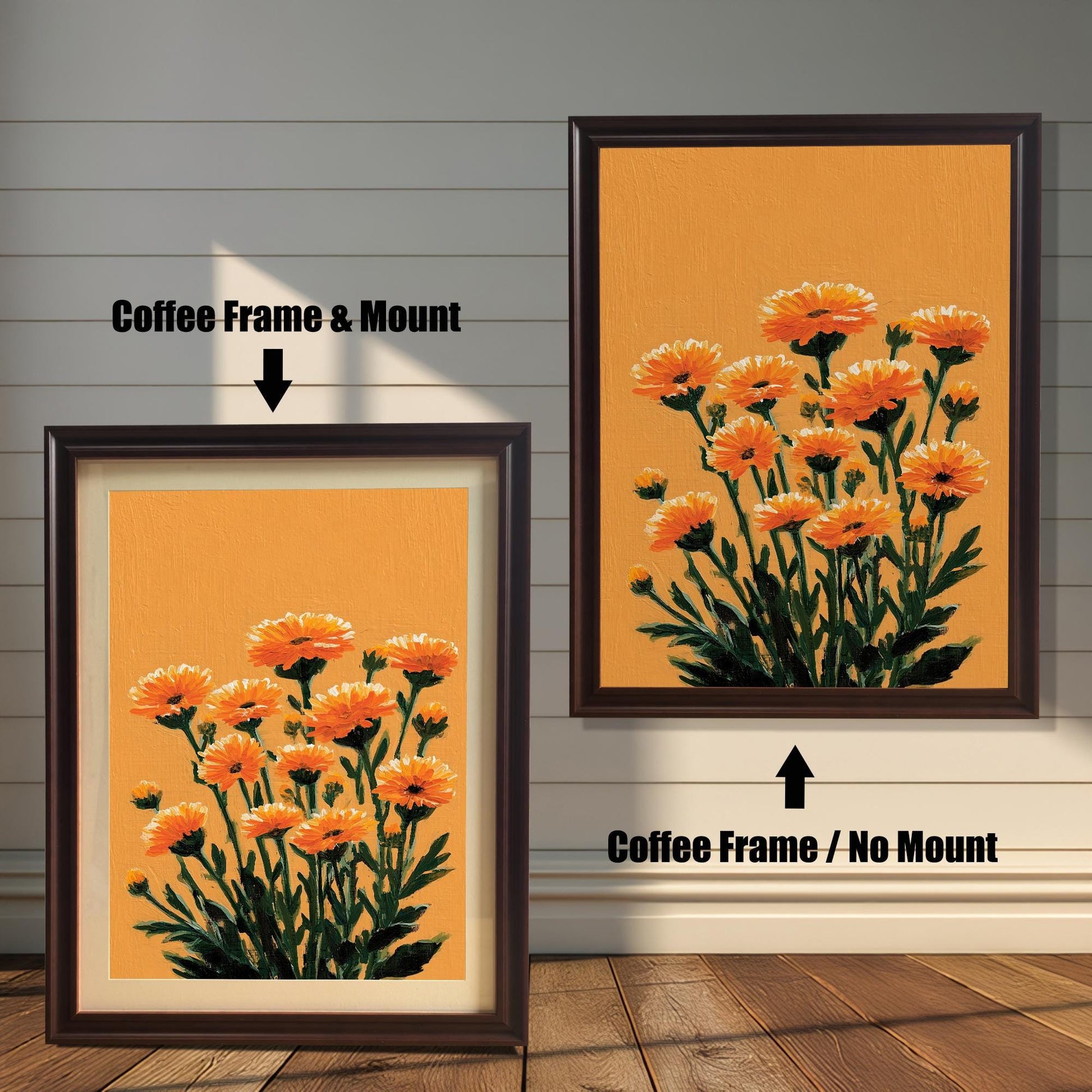 Two framed orange floral art prints against a white wood panel wall and wood floor. The print on the left has a Coffee Frame & Mount (matting). The print on the right has a Coffee Frame / No Mount.