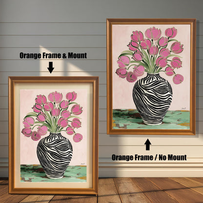 Zebra Vase and Pink Tulips art print shown in two orange wood frames on a rustic wood panel wall. The left frame includes a mount/mat, and the right frame shows the print without a mount/mat.