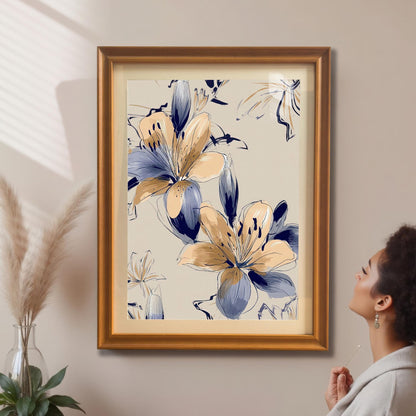 A woman looking up at the framed Navy and Beige Lily print in an orange/gold frame with a mat/mount hanging on a beige wall, next to pampas grass decor.