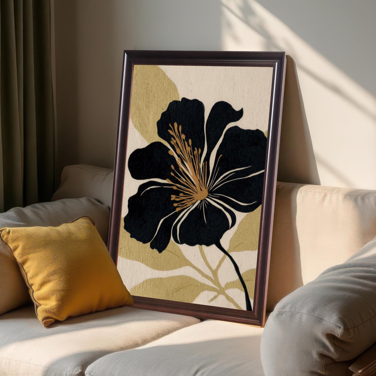 A framed black and gold floral art print leaning against a cream-colored sofa with a yellow pillow, showing a cozy, sunlit interior display. The frame is a dark, wood-like 'Coffee' color.