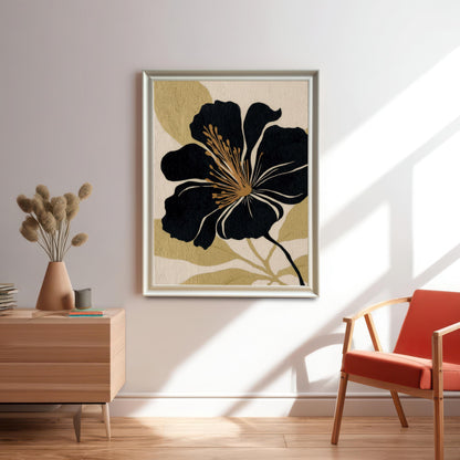 The black and gold abstract floral art print in a Silver or Light-Colored Frame hangs on a white wall in a sunlit room. It is positioned above a wooden side table with dried grasses in a terracotta vase, next to a modern chair with an orange cushion.
