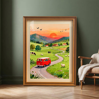 A large, framed art print of a red van driving through a hilly, green countryside at sunset, leaning on a wooden floor against a dark green wall, next to a modern armchair. The frame is a warm Orange/Gold color.