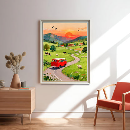 The art print of the red camper van road trip scene hangs on a bright white wall in a Silver or Light-Colored Frame. It is positioned over a wooden dresser with dried flowers, next to a modern chair with an orange cushion, bathed in natural sunlight.
