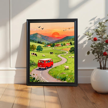 A framed print of a red camper van driving on a road winding through a green countryside at sunset. The print is in a Black Frame and rests on a wooden floor against a white paneled wall, with a small potted plant on the right.