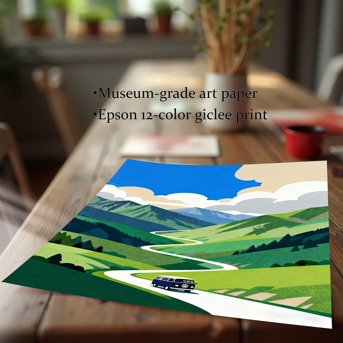 A close-up view of the unframed print featuring a blue van on a winding road through green mountains. The print rests on a wooden table, with text confirming the quality: Museum-grade art paper and Epson 12-color giclee print.